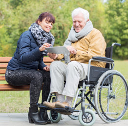 caregiver and senior man looking at a tablet