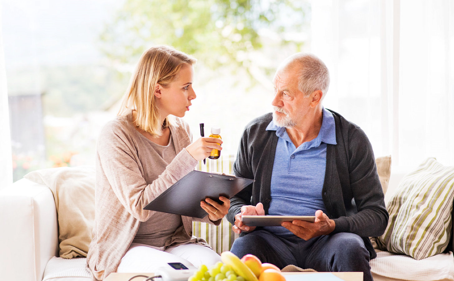 caregiver showing medicine to a senior man