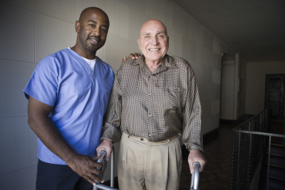 caregiver and a senior man smiling