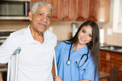 caregiver with stethoscope assisting a senior man