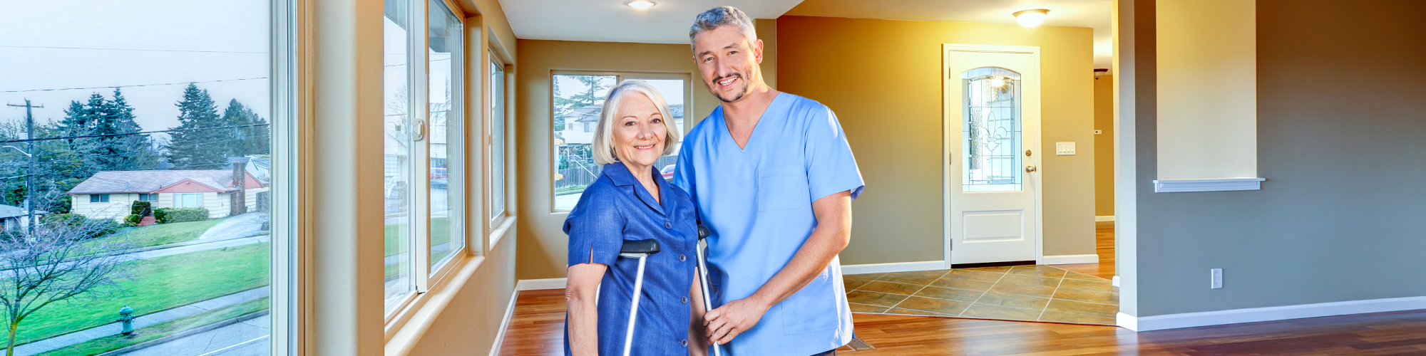 senior woman with cruches and a caregiver smiling